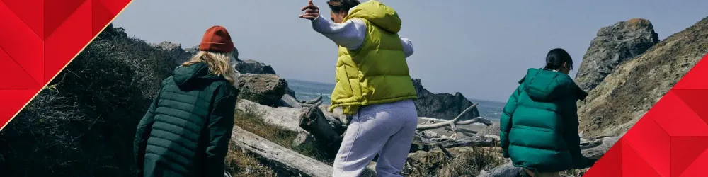 Three friends wearing lululemon gear at they explore a rocky coast